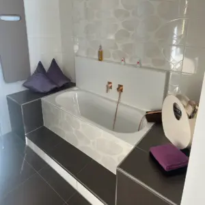 Moderne Einbau-Badewanne mit Designfliesen und Unterputzarmatur