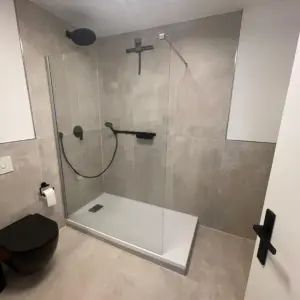Moderne Dusche mit schwarzen Armaturen und Glasabtrennung Badsanierung WärmeFix Haustechnik Marl Umgebung