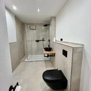 Modernes Badezimmer Walk-In Dusche schwarzes WC Badsanierung durch WärmeFix Haustechnik Marl und Umgebung