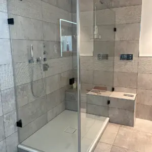 Moderne Dusche mit grauen Fliesen Sitzbank und Glasabtrennung Badsanierung Marl Umgebung