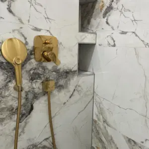Moderne Dusche mit Marmoroptik Fliesen und goldenen Armaturen hochwertige Badsanierung Marl Umgebung
