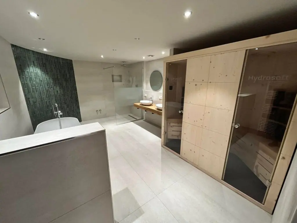 Modernes Luxusbad mit integrierter Sauna, freistehender Badewanne und großer Walk-in-Dusche