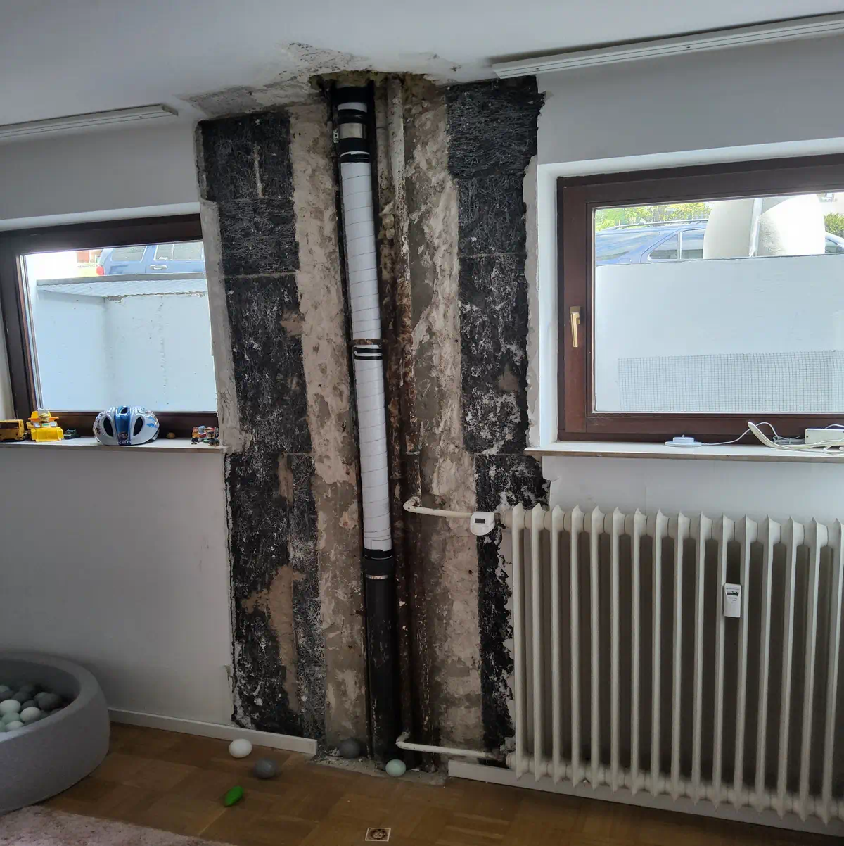 Rohrbruch im Wohnraum mit freigelegten Leitungen und Wasserschaden – SHK Notdienst im Einsatz