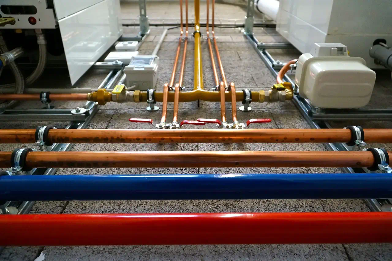 Trinkwasserinstallation mit Kupferleitungen und Absperrventilen im Technikraum